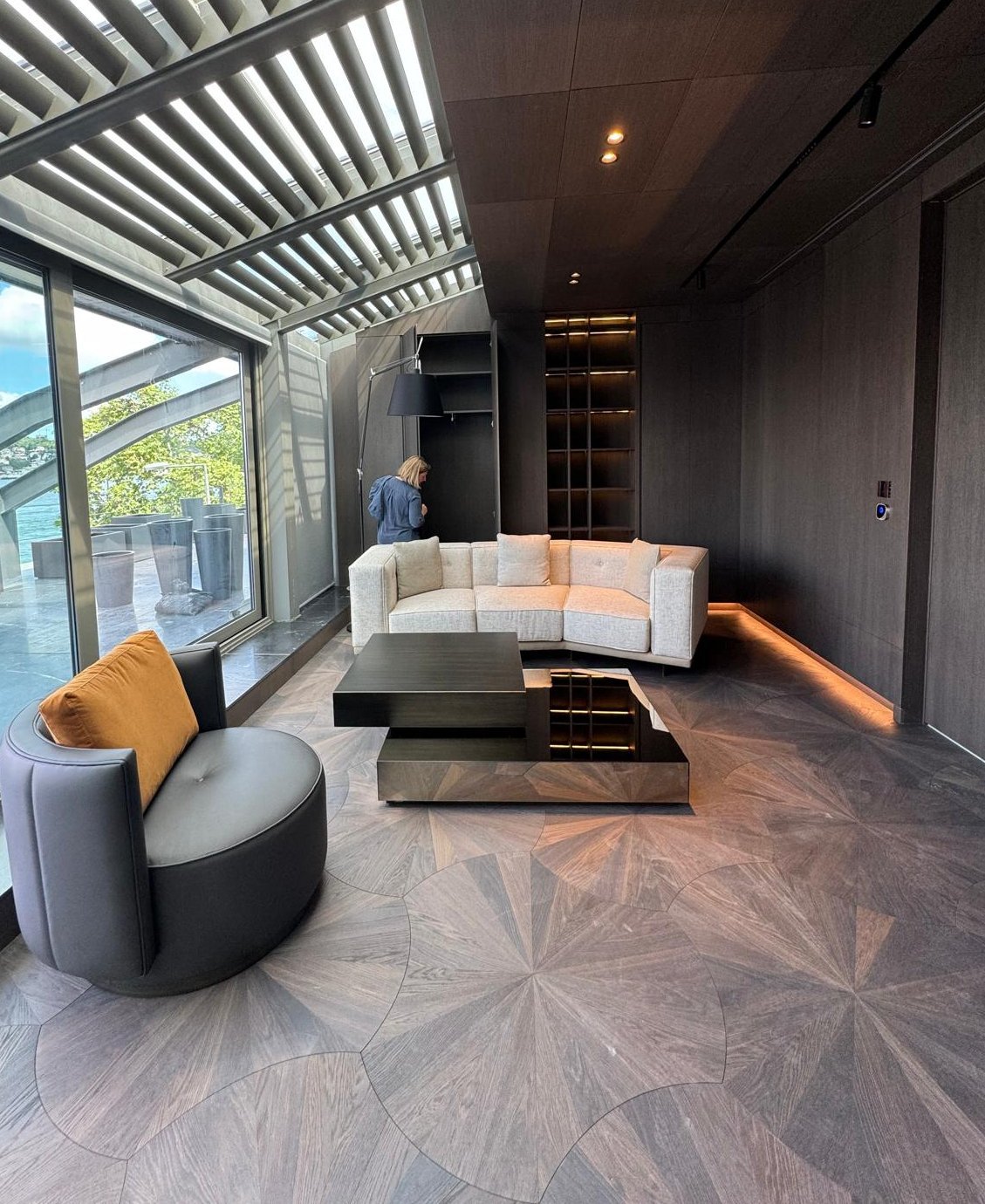 Eichen-Parkettboden mit einzigartigem Muster in modernem Wohnzimmer mit weißem Sofa, Couchtisch, Sessel und Fensterfront.