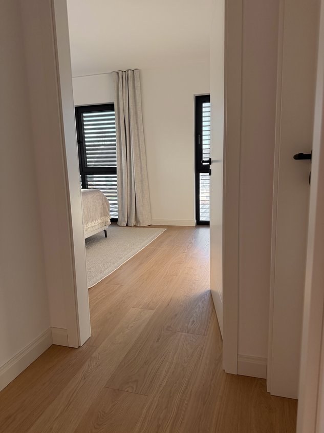 Blick in ein minimalistisches helles Schlafzimmer mit Landhausdielen in Eiche weiß