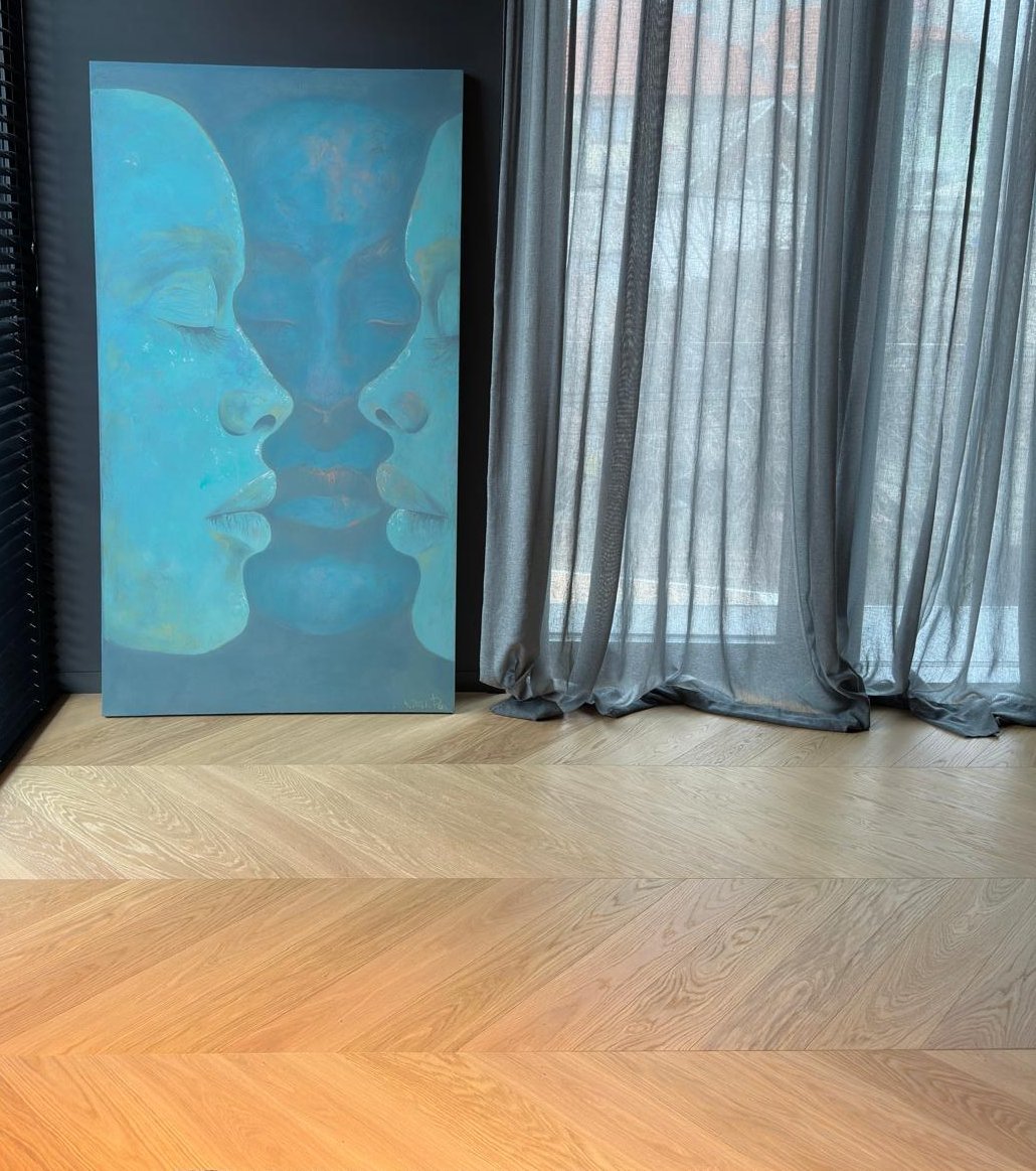 Room with dark walls and French herringbone parquet flooring in white oak, as well as a turquoise painting with two faces.