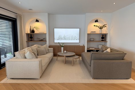 Wohnimmer mit Rundbögen in modernem Stil und hellen Sofas auf Eichenparkett