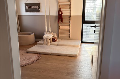 Minimalistisches Kinderzimmer mit natürlichem Eichenboden und Schaukel