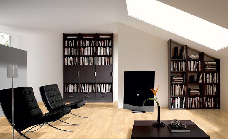 Wohnzimmer mit Eschenholzboden, dunklen Möbeln und Dachfenster, das den hellen Parkettboden beleuchtet.