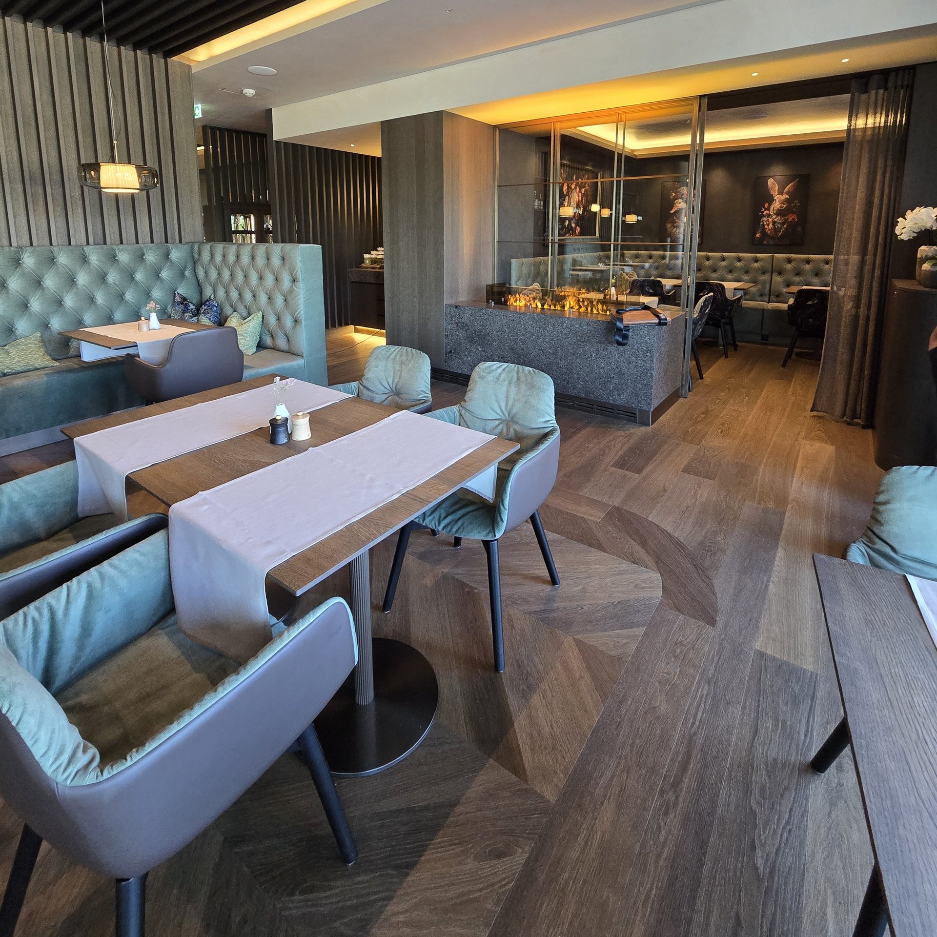 Edles Restaurant mit Fischgrat und Landhausdielen Eiche und hellgrünen Samtmöbel