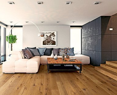 Wohnzimmer mit schwarzer Wand und Treppe, ausgestattet mit braunem rustikalen Eichenparkettboden und einer weißen Couch, die eine moderne und einladende Atmosphäre schaffen