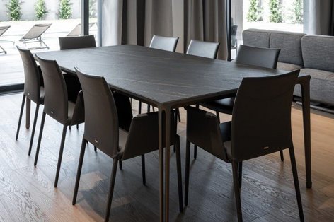 Esszimmer mit dunkelbraunem Tisch und Stühlen auf hellem Eichenparkett