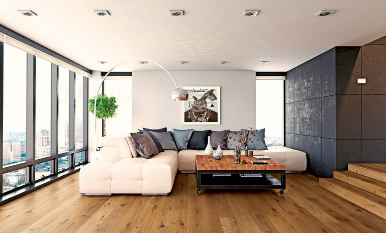 Wohnzimmer mit Eichenholztreppe und passendem Parkettboden, weißem Sofa, Holztisch und Wand mit dunkelgrauen Platten.