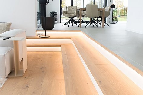 Illuminated oak steps lead to a living room and on the upper floor there is a dining room with a gray floor