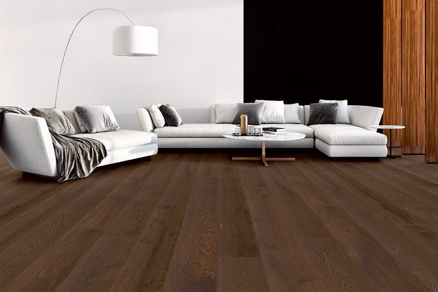 Dunkles Eichenparkett mit riesiger Wohnlandschaft in Grau-Tönen und Pendelleuchte