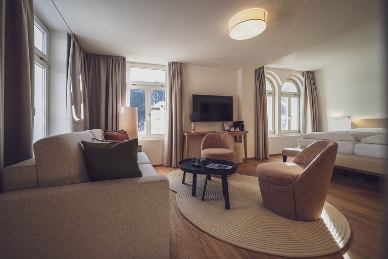 Gemütliches Hotelzimmer mit beigefarbenem Teppich auf Eichenparkett