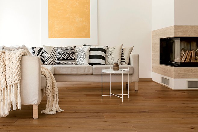 Naturfarbenes Sofa und Kamin mit gedämpften Eichenparkett