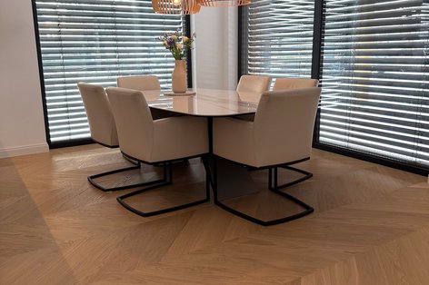 Französischer Fischgrätboden in Eiche unter einem Esstisch aus Marmor und Lederstühlen