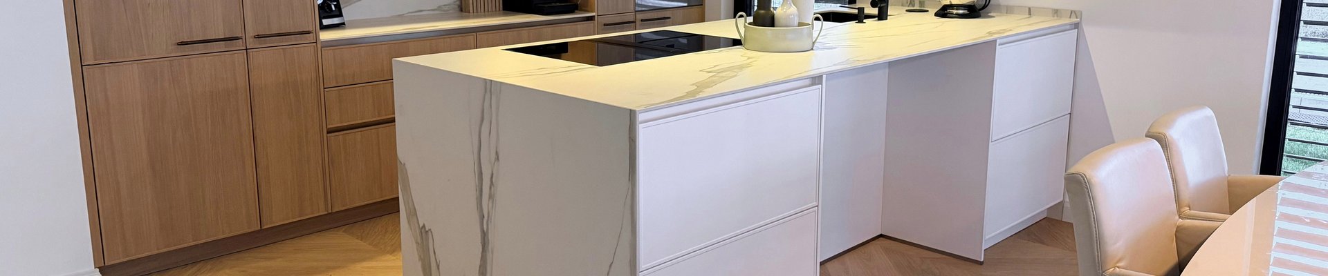 Moderne Küche mit Französisch Fischgrät Parkett aus Eiche, weißem Marmor-Küchenblock und Eichenholzschränken