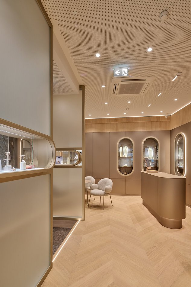 Französisch Fischgrät Parkett in Uhrengeschäft Salzburg. Goldenes Design und helles Eichenparkett