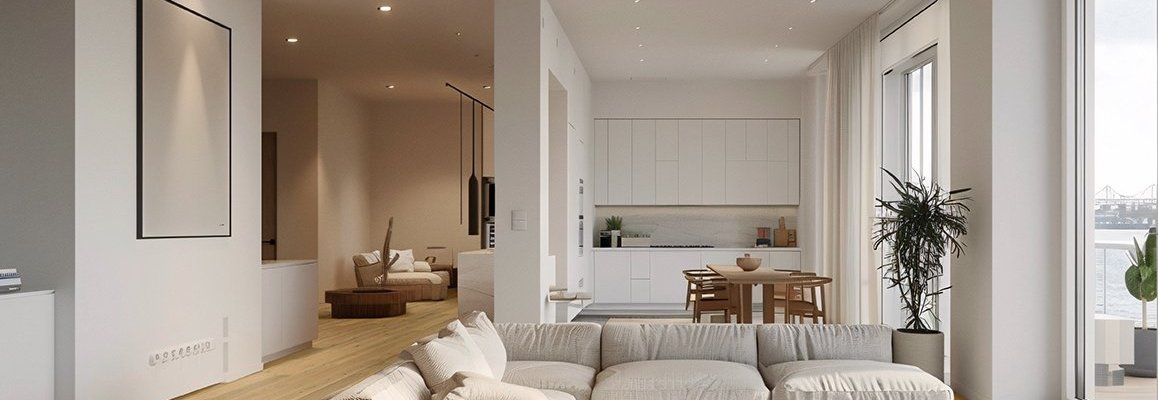 Parkettboden aus Eiche in einem modernen, offenen Wohnraum mit großer Fensterfront. Im Wohnraum befindet sich eine beige Couch und eine weiße Küche mit Holztisch und Holzstühlen davor. Ein beleuchteter Gang mit Spots führt in einen weiteren Raum.