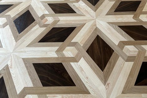 Parkettboden verlegt mit verschiedenen Holzarten zu einem besonderen Verlegemuster mit historischem Wappen