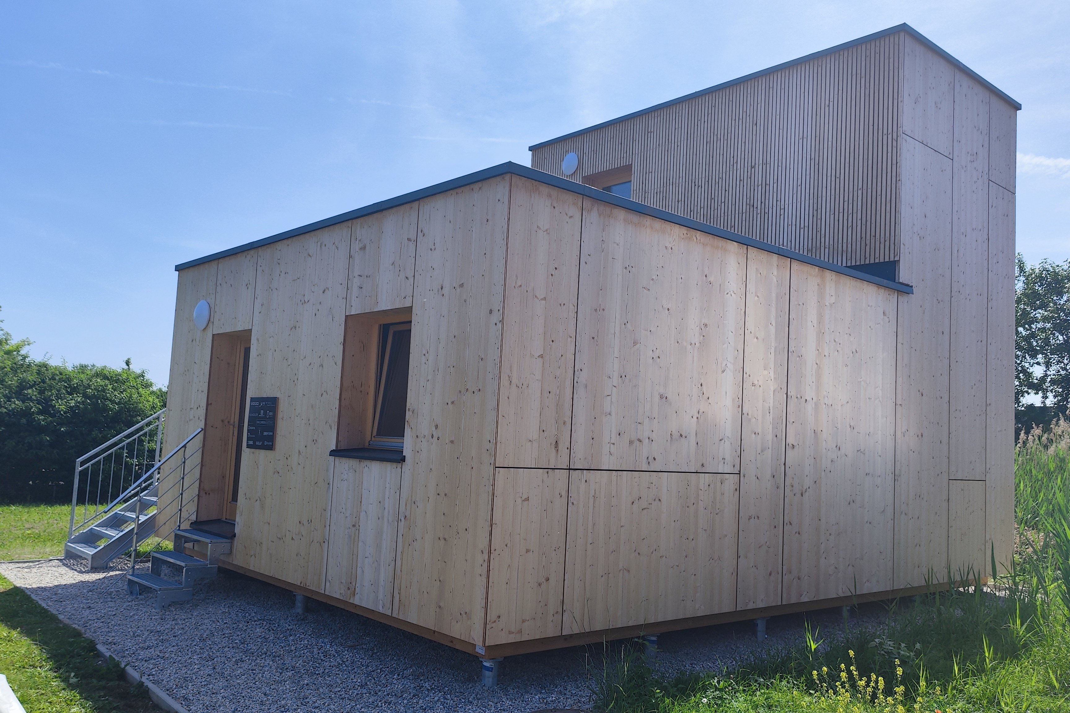 Designerhaus aus Holz in einer grünen Wiese