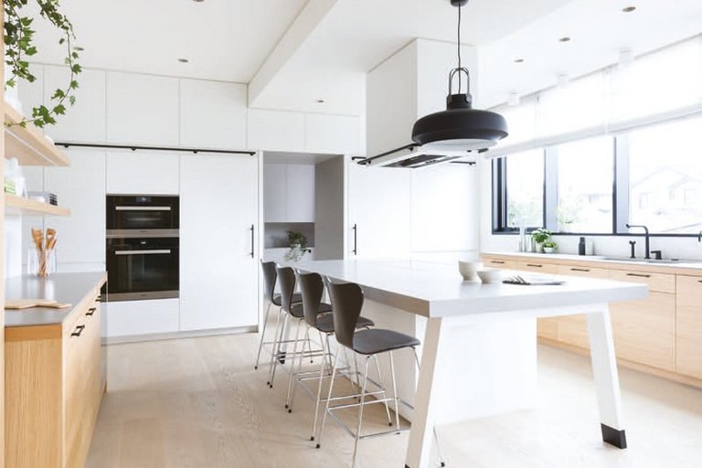 [Translate to EN:] Minimalistische Küche in Weiß mit Parkettboden hell