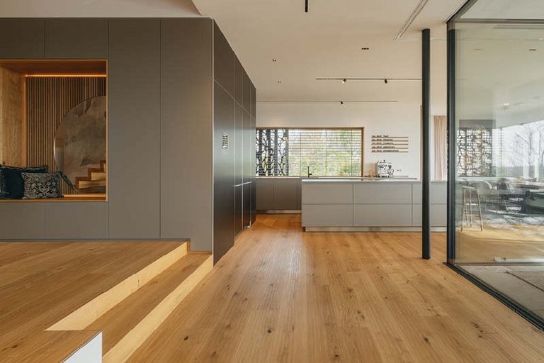 [Translate to EN:] Große Fläche Boden und Treppe mit Eiche rustikal als Landhausdiele und eine Küche in grau
