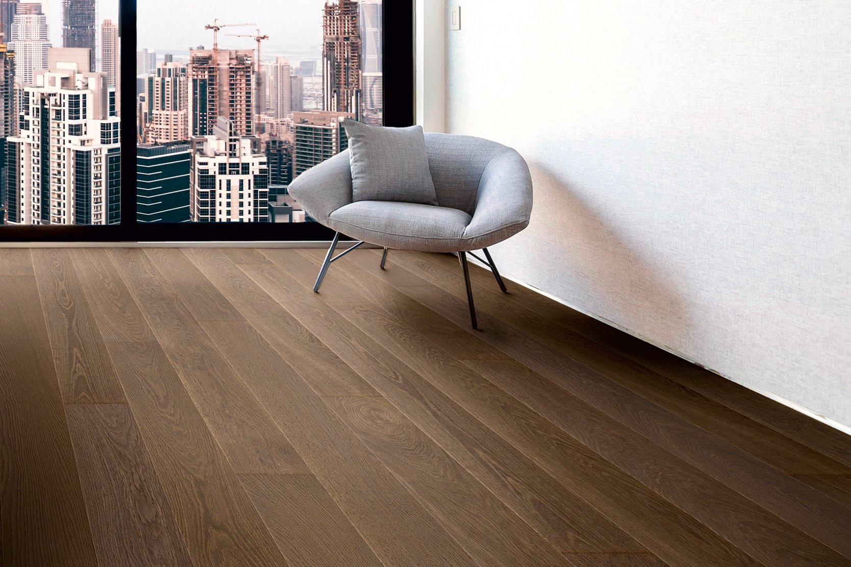 Room in a high-rise building with dark oak parquet flooring and floor-to-ceiling windows offering a view of the city skyline
