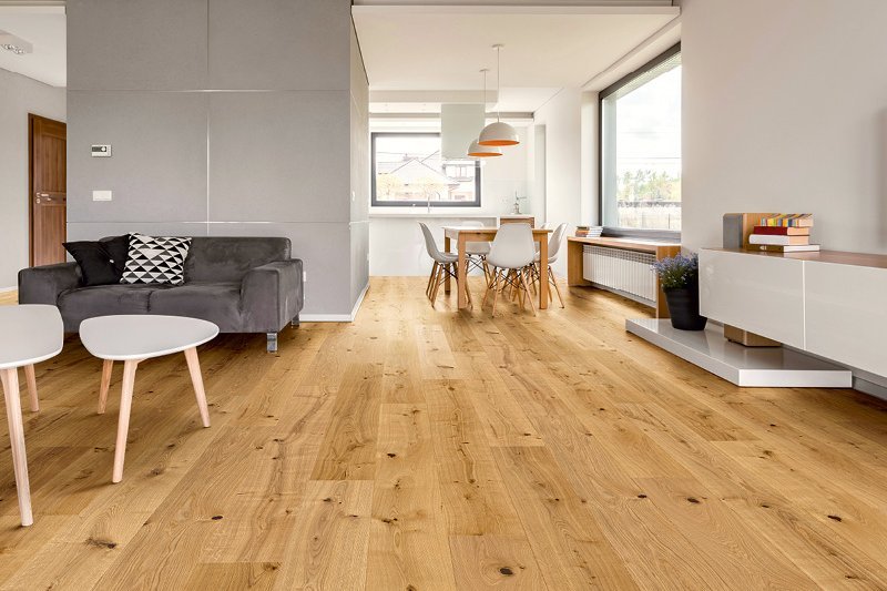 Apartment with dining area and couch on rustic oiled oak floorboards