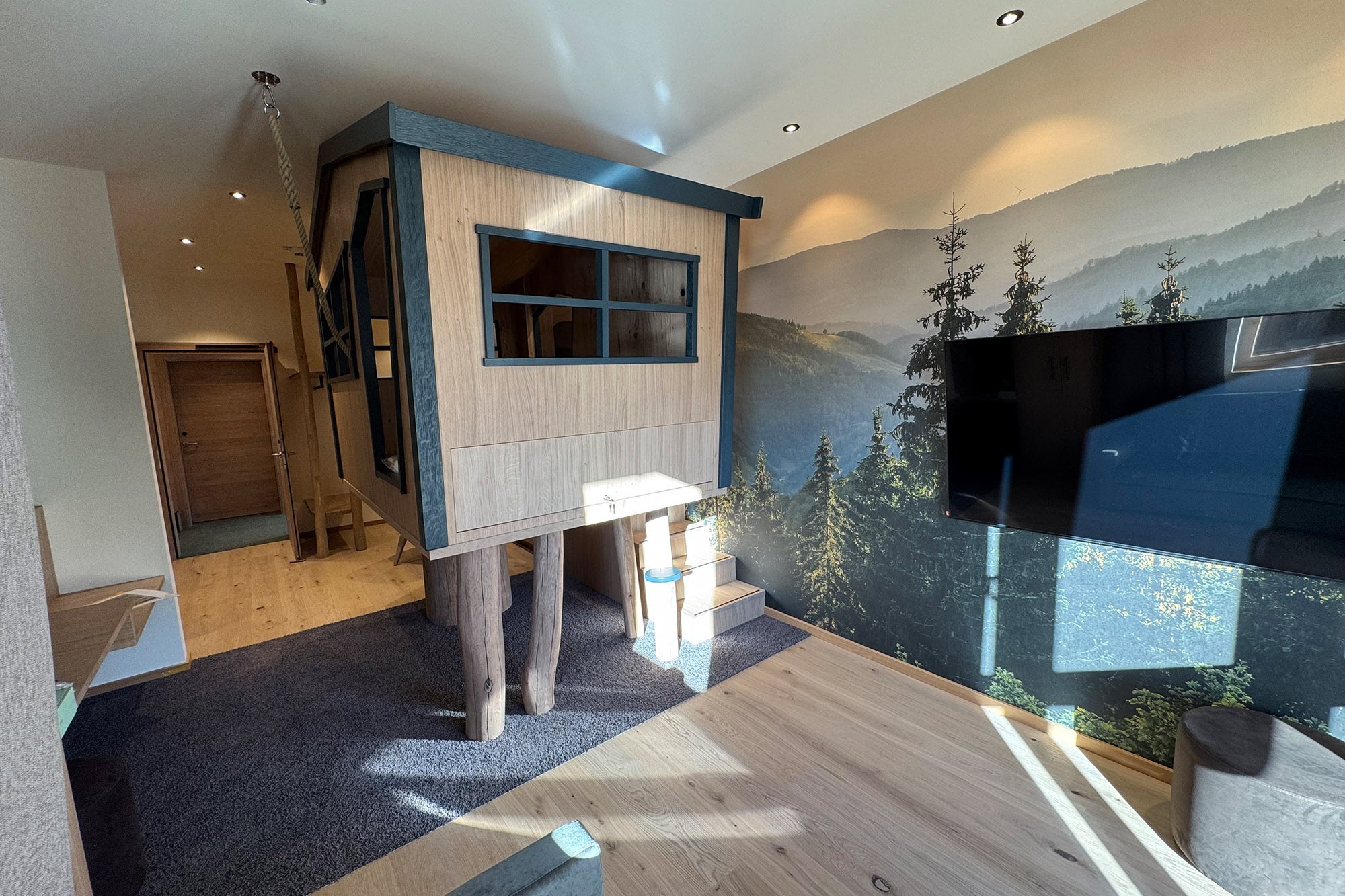 Hotelzimmer mit modernem Baumhäuschen für Kinder aus Holz auf Holzboden