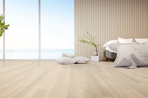 Schlafzimmer mit Holzboden in Cloud-Dancer-Farbton, Bett davor platziert, Blick auf helle, wolkenhafte Atmosphäre – ruhiges, luftiges Interior in sanften Weiß- und Naturtönen.