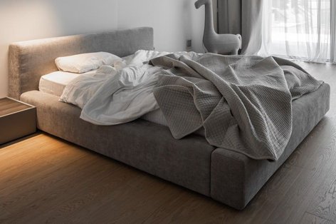 Schlafzimmer mit Landhausdielen Eiche weiß und grauem Stoffbett