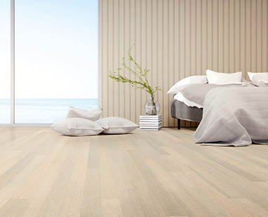 Light-flooded bedroom in light beige tones and matching oak parquet flooring