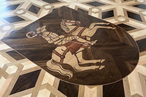 PArkett in besonderem Verlegemuster aus verschiedenen Holzarten mit kultureller Inschrift