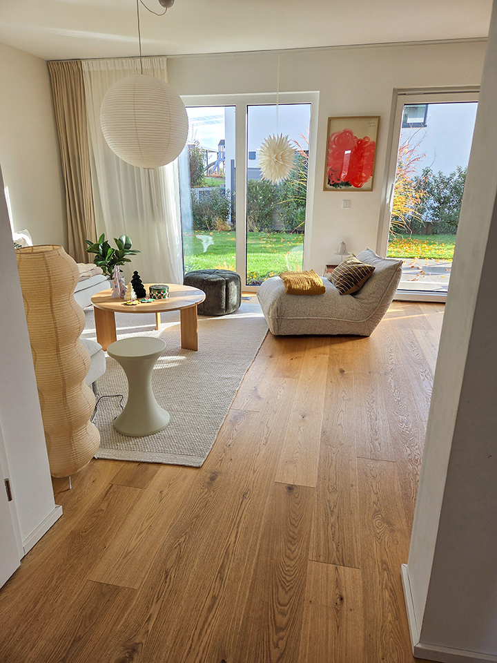 Landhausdiele Eiche Astig Valletta Seda Natura Helles Wohnzimmer mit Eiche-Landhausdielen, großen Fenstern und gemütlichen Sitzgelegenheiten in natürlicher Wohnatmosphäre